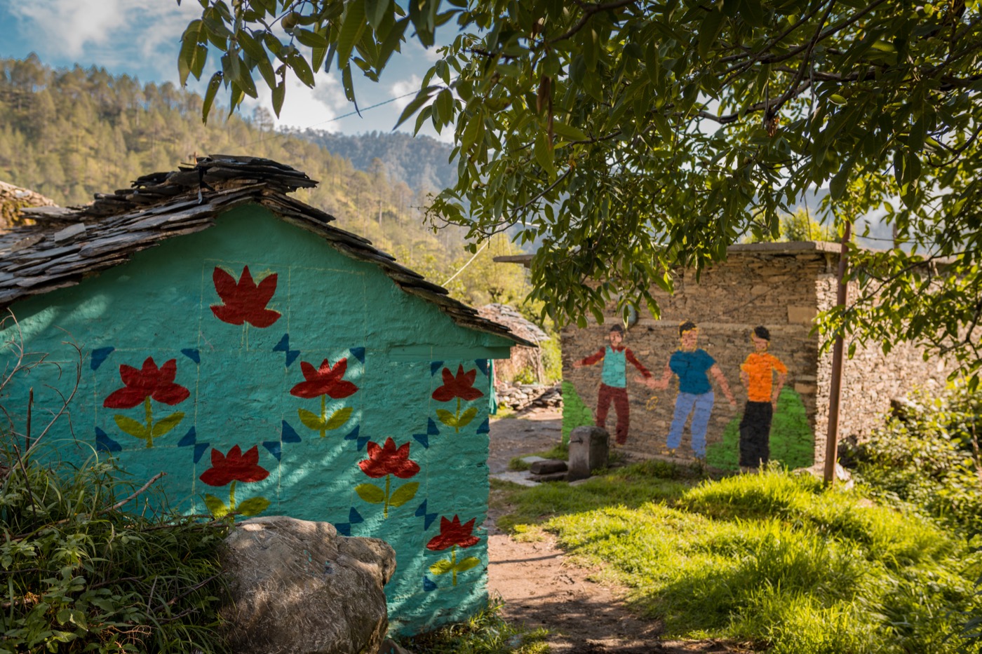 Village houses painted with red flowers and figures, in the hills of Uttarakhand